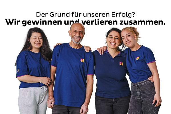 Three women and one man wearing blue T-shirts with the Piepenbrock logo are hugging each other and smiling at the camera.
